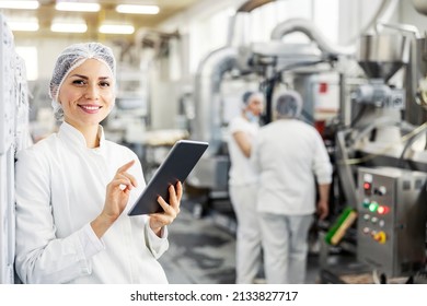 Portrait of female food factory inspector using tablet and smiling at the camera. - Shutterstock ID 2133827717