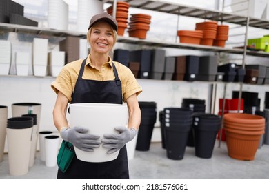 Portrait Of Female Garden Center Worker With Plant Pots