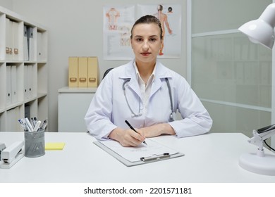 Portrait Of Female General Practitioner Sitting At Desk In Medical Office