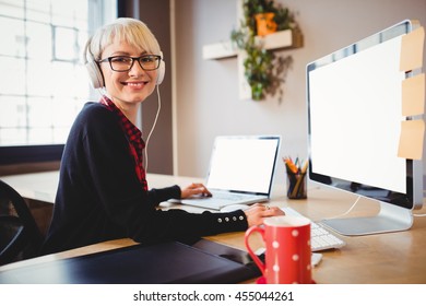 Portrait Of Female Graphic Designer Working On Computer And Laptop At Office