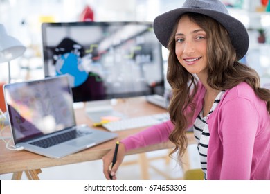 Portrait Of Female Graphic Designer Working At Desk In The Office