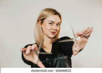 Portrait Of A Female Hairdresser Of European Appearance. Scissors In Hand. High Quality Photo