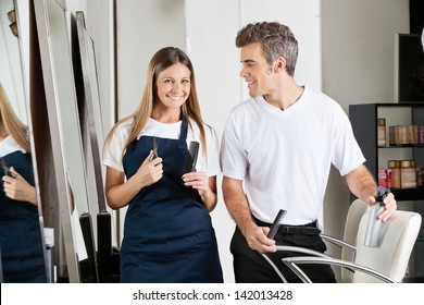 Portrait of female hairstylist with male colleague in beauty salon - Shutterstock ID 142013428