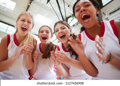 Portrait Of Female High School Basketball Team Celebrating On Court