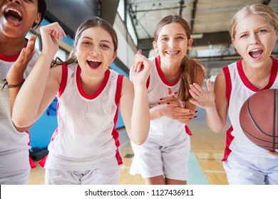 Portrait Of Female High School Basketball Team Celebrating On Court