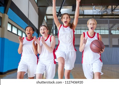 Portrait Of Female High School Basketball Team Celebrating On Court