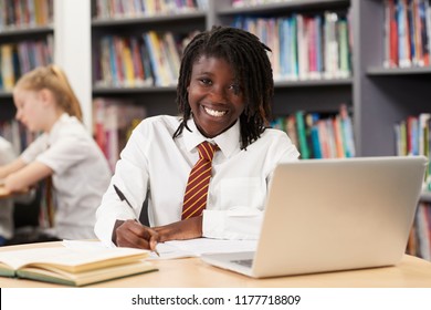 Portrait von weiblichen High School-Schülern, die an Laptop in der Bibliothek arbeiten