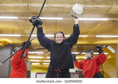 Portrait Of Female Hockey Team Cheering While Celebrating Victory On Skating Rink, Copy Space