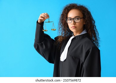 Portrait Of Female Judge With Scales Of Justice On Color Background