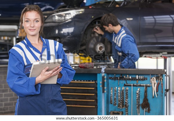 portrait\
of a female mechanic in a automotive workshop\
