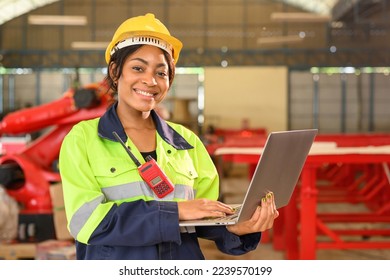 Portrait of female mechanical engineer worker in yellow hard hat and safety uniform using laptop standing at manufacturing area of industrial factory - Powered by Shutterstock