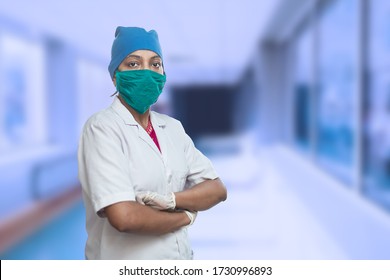 Portrait Of Female Medical Worker Doctor Wearing Surgical Mask And Cap Standing Crossed Arms Outside Hospital Corridor. New Strain Of Covid-19, Coronavirus Pandemic. Copy Space, Omicron Cases In India