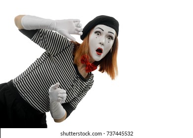 Portrait of female mime artist on white. Woman playing a pantomime performance, showing surprised face and looking out of the imaginary wall.