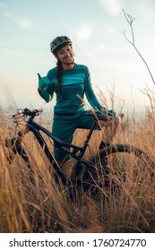 Portrait Of Female Mountain Bike On Trail. Dressed In Blue In Meadow With Plants In Spring / Summer. In The Collserola Mountain, Barcelona. Mountain Biking Woman With Cross Contry Bike, Xc Mtb