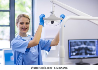 Portrait of female nurse adjusting dental light in clinic - Powered by Shutterstock