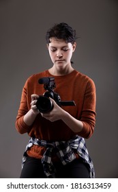 Portrait Of A Female Online Content Creator Holding A Video Camera Used For Vlogging.  She Is An Amateur Filmmaker Or An Art Student