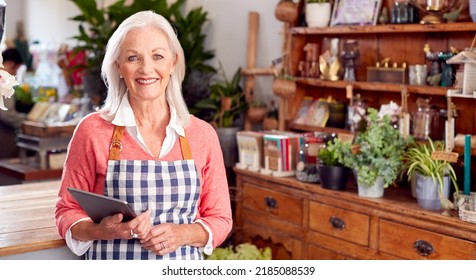 Portrait Of Female Owner Of Florists Shop Using Digital Tablet Receiving Online Order