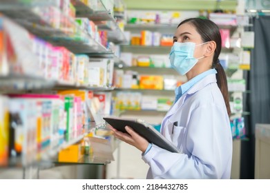 A Portrait Of Female Pharmacist Wearing Face Mask In A Modern Pharmacy Drugstore.