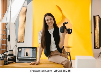 Portrait of a female photographer with a camera in her hands against the background of the interior of a photo studio. - Powered by Shutterstock