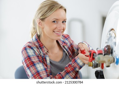 portrait of female plumber working on boiler - Shutterstock ID 2125300784