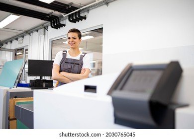 Portrait Of Female Print Worker Standing By Computer To Plate Machine In Print Shop.