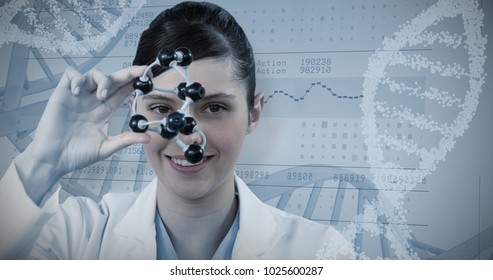 Portrait Of Female Scientist Holding Molecular Model Against Panoramic View Of Information Data