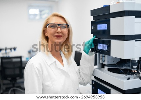 Portrait of female scientist loading samples into HPLC autosampler.