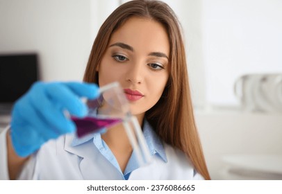 Portrait of female scientist pour pink liquid from flask in medical chemistry lab. Chemist doing experiment in laboratory. Science, discovery, test concept - Powered by Shutterstock