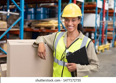 Portrait of female staff smiling while standing in warehouse. This is a freight transportation and distribution warehouse. Industrial and industrial workers concept