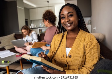 Portrait of female student learning at home with her friends.