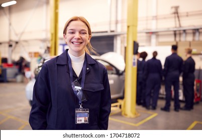 Portrait Of Female Student With Safety Glasses Studying For Auto Mechanic Apprenticeship At College