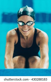 Portrait Of Female Swimmer On Pool Edge