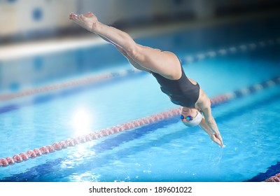 Portrait Of A Female Swimmer, That Jumping And Diving Into Indoor Sport Swimming Pool. Sporty Woman.