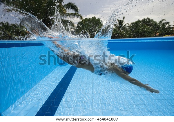 プールに飛び込んで飛び込む女性の泳ぎ手のポートレート スポーティーな女性 プールから低い角度の景色 の写真素材 今すぐ編集