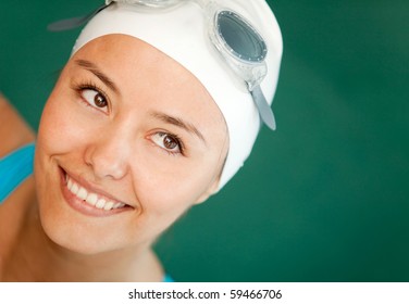 Portrait of a female swimmer wearing hat and goggles and smiling - Powered by Shutterstock