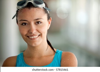 Portrait of a female swimmer wearing swimming goggles and smiling - Powered by Shutterstock