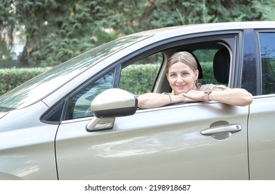 Portrait Of Female Taxi Driver Driving Her Car.