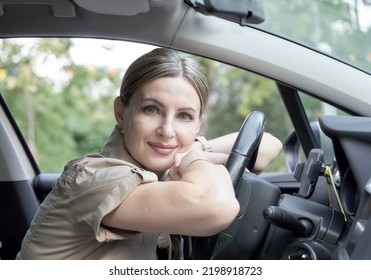 Portrait Of Female Taxi Driver Driving Her Car.