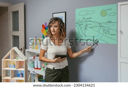 Similar – Image, Stock Photo Teacher explaining types of renewable energies in poster at ecology classroom