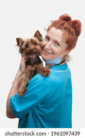 Portrait Of Female Veterinary Doctor In Medical Uniform With Dog In Hands On Isolated White Background