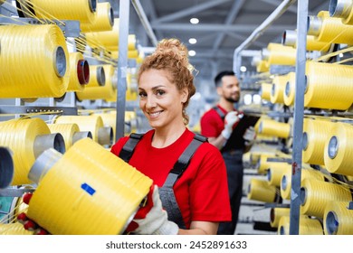 Portrait of female worker holding thread spool inside textile factory. - Powered by Shutterstock