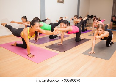 Portrait Of A Female Yoga Instructor Teaching A Yoga Class To A Large Group Of People