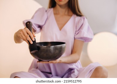 Portrait Of A Female Yoga Teacher Playing A Tibetan Bowl Or Singing A Bell In The Gym During A Yoga Retreat.