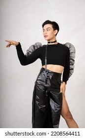 Portrait Of A Feminine Man In Black Dress And Black Hair While Wearing Makeup Inside The White Studio