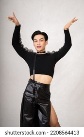 Portrait Of A Feminine Man In Black Dress And Black Hair While Wearing Makeup Inside The White Studio