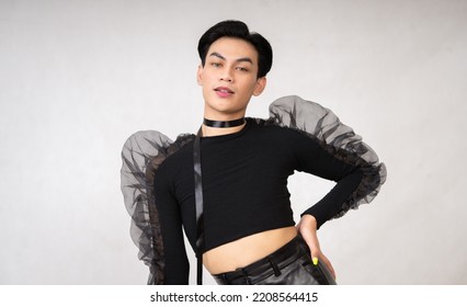 Portrait Of A Feminine Man In Black Dress And Black Hair While Wearing Makeup Inside The White Studio