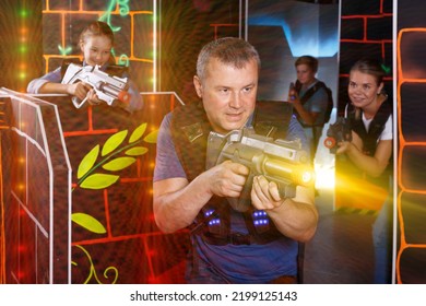 Portrait Of Fine Man With Laser Gun Having Fun With Family On Laser Tag Arena