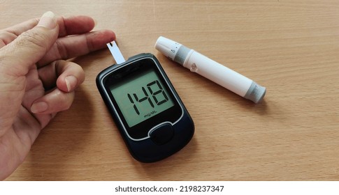 Portrait The Fingertip Check Of Diabetes, Showing High Blood Sugar On Monitor, Hyperglycemia Patient Woman Take Proactive Control, Concept Health Care. 