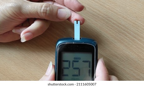 Portrait Fingertip Check, Showing High Blood Sugar On Monitor, Patient Take Proactive Control, Concept Health Care.