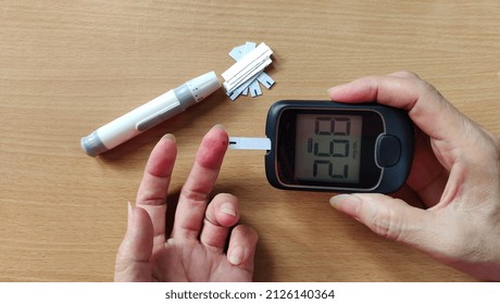 Portrait Fingertip Check, Showing High Blood Sugar On Monitor, Patient Diabetes Take Proactive Control, Concept Health Care.